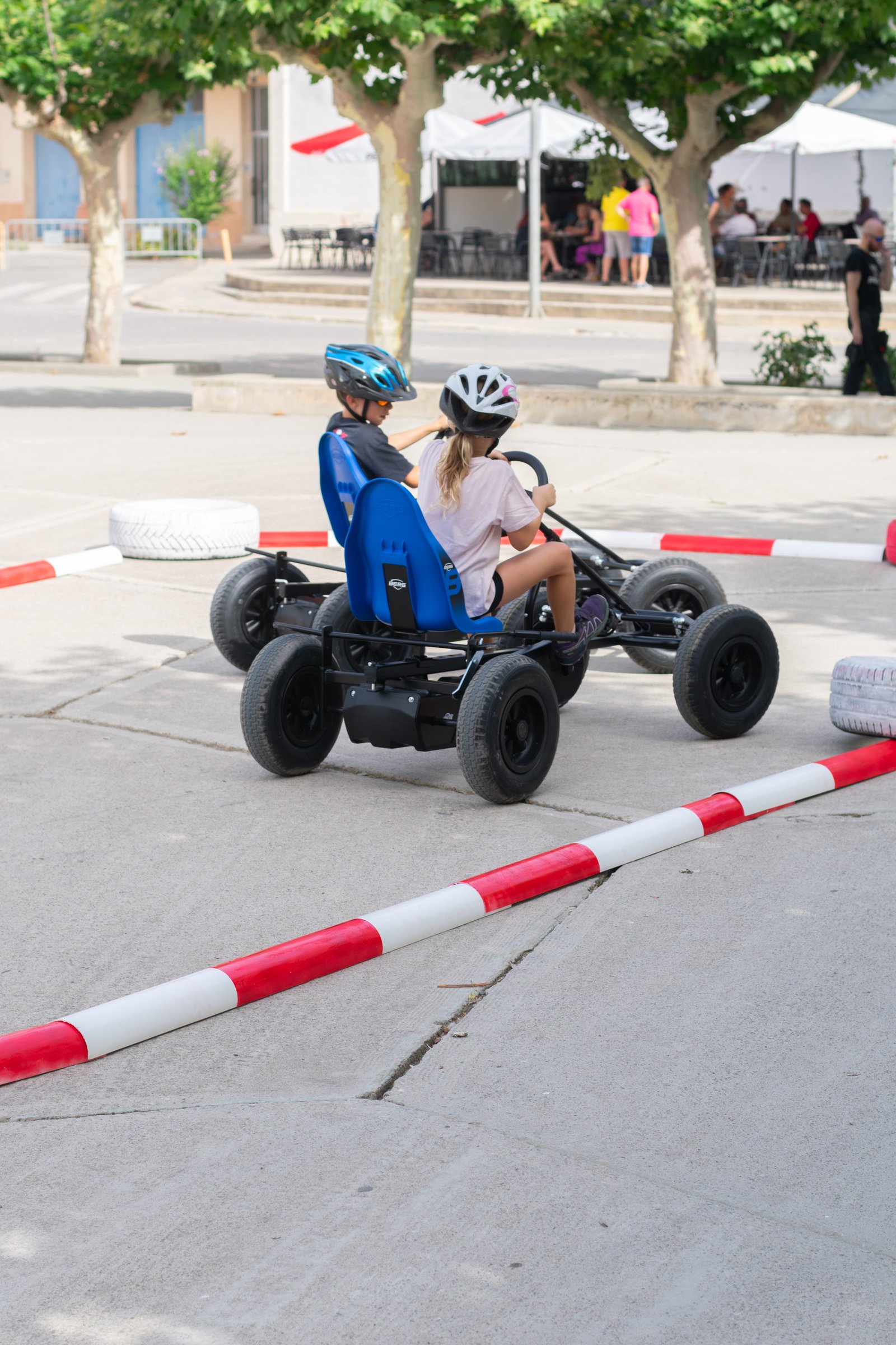 Kart a pedales circulando entre neumáticos y separadores en una plaza